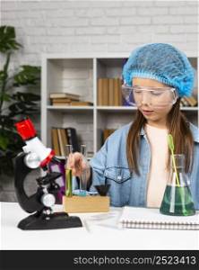 girl with hair net doing science experiments with microscope