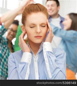 girl with headache holding her head with hands at school