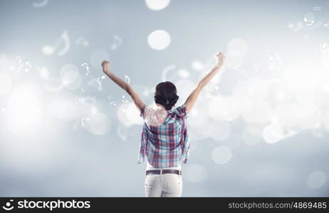 Girl with headphones. Rear view of young girl in casual wearing headphones