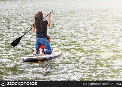 Girl with her baby stand up paddle boarding (sup)
