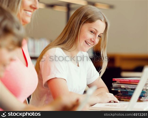Girl with her famile on background in library with computer. Girl in library with computer