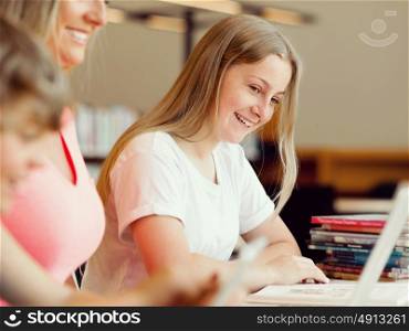 Girl with her famile on background in library with computer. Girl in library with computer