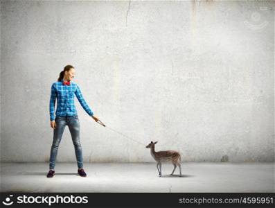 Girl with kangaroo. Young woman in casual holding deer on lead