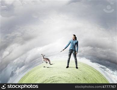Girl with kangaroo. Young woman in casual holding kangaroo on lead