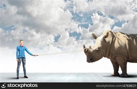 Girl with kangaroo. Young woman in casual holding rhino on lead