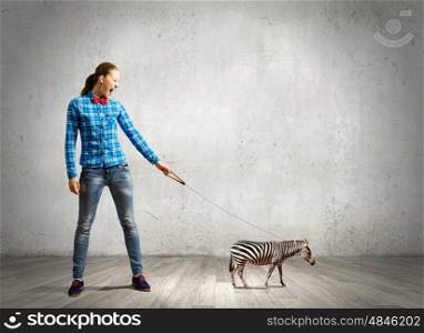 Girl with kangaroo. Young woman in casual holding zebra on lead