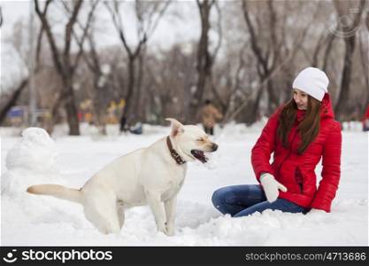 Girl with labrador dog on walk in winter park. Winter activity