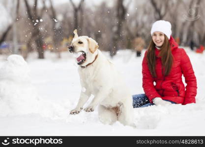 Girl with labrador dog on walk in winter park. Winter activity