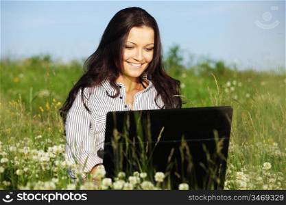girl with laptop on green grass