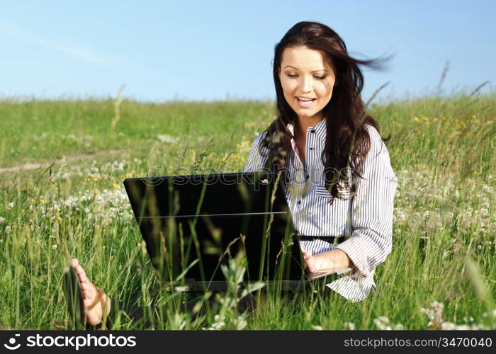 girl with laptop on green grass