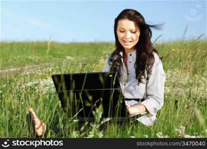 girl with laptop on green grass