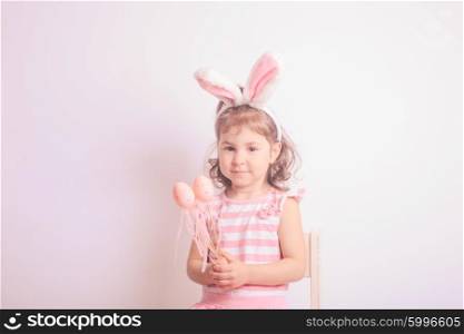 Girl with little pink eggs for the Easter hunting. Pink decorative eggs