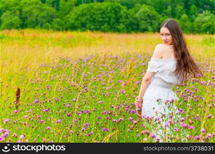 girl with long hair in a field with purple flowers
