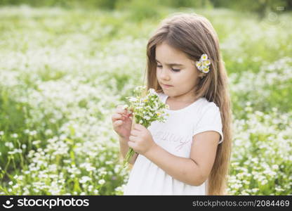 girl with long hair looking white flowers collected by her field