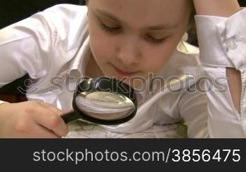 girl with magnifier studies a map of Europe.