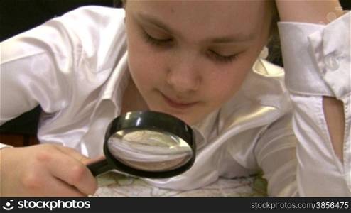 girl with magnifier studies a map of Europe.