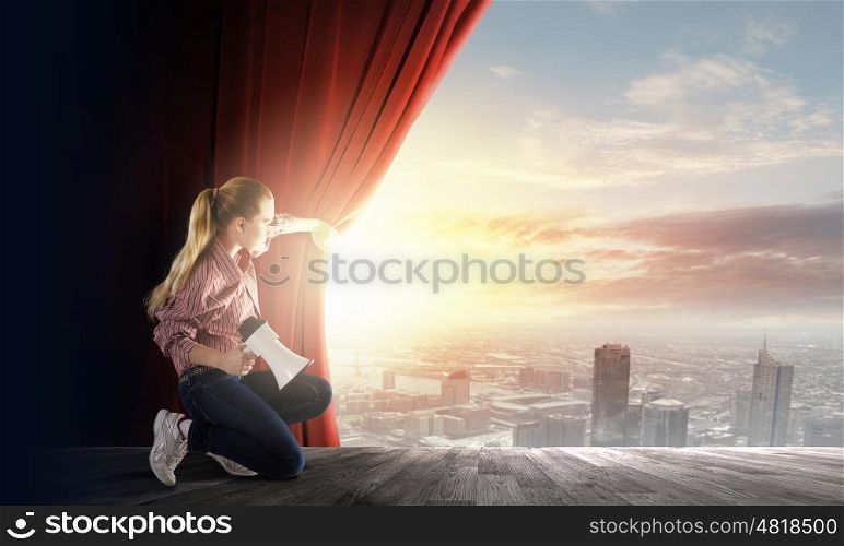 Girl with megaphone. Young girl on stage with megaphone opening red curtain