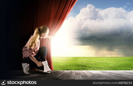 Girl with megaphone. Young girl on stage with megaphone opening red curtain