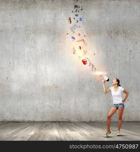 Girl with megaphone. Young teenager girl in shorts screaming in megaphone