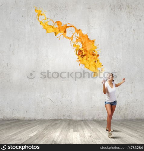 Girl with megaphone. Young teenager girl in shorts screaming in megaphone