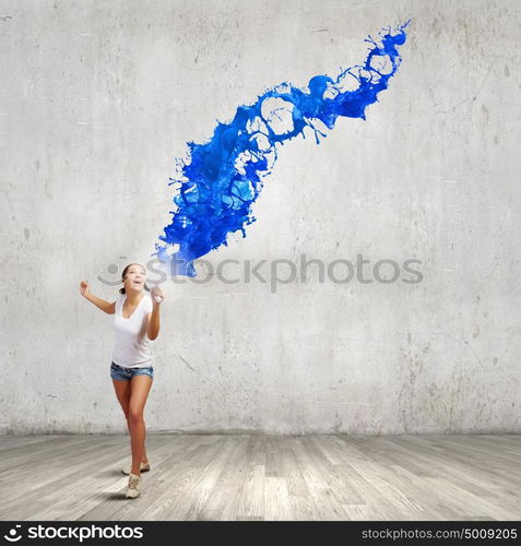 Girl with megaphone. Young teenager girl in shorts screaming in megaphone