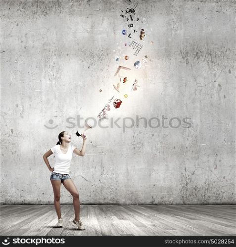 Girl with megaphone. Young teenager girl in shorts screaming in megaphone