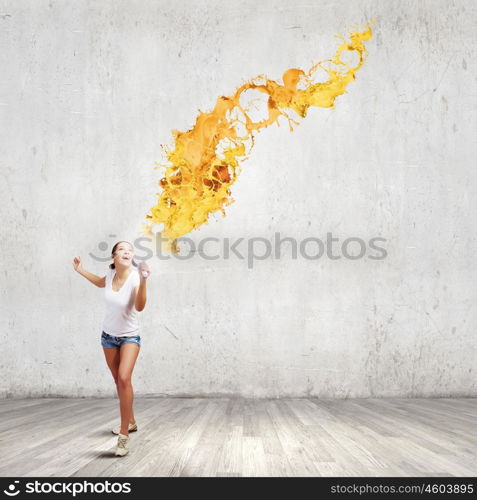 Girl with megaphone. Young woman in casual speaking in megaphone with colorful splashes flying out