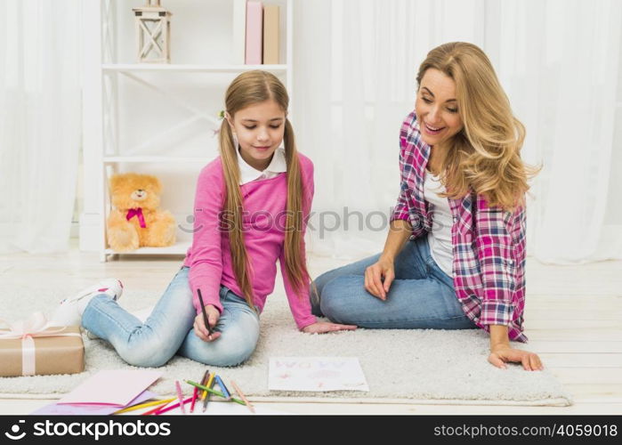 girl with mother drawing paper floor