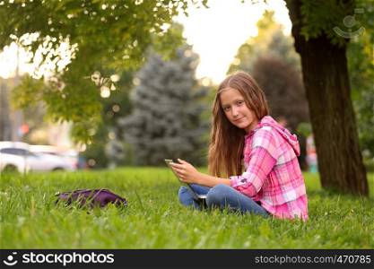 Girl with notebook sitting at the grass