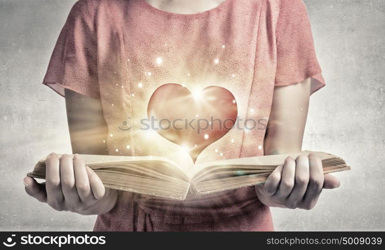 Girl with novel book. Young emotional woman in red dress with book in hand