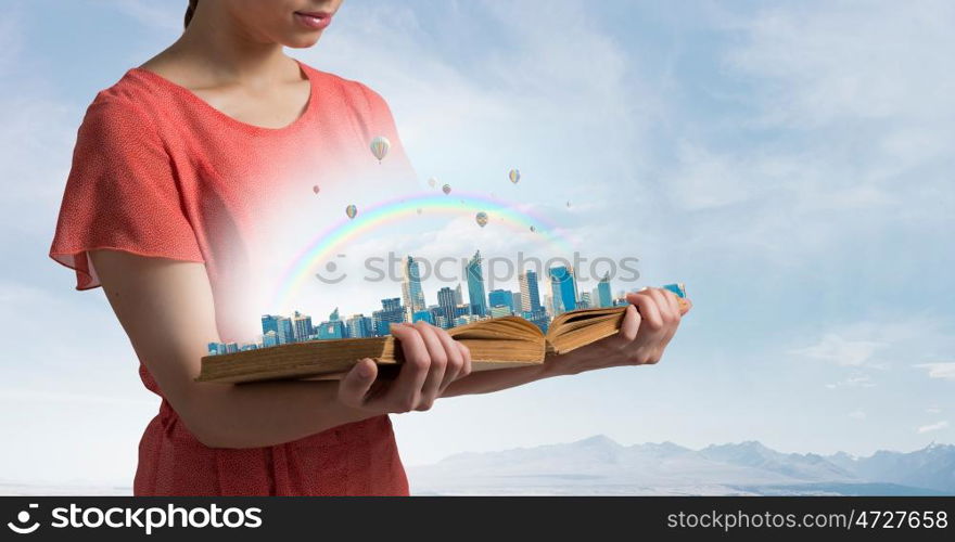 Girl with opened red book. Close view of woman holding opened book and construction concept on pages