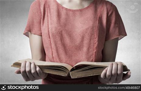 Girl with opened red book. Close view of woman holding opened book and light coming from pages