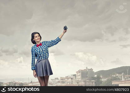 Girl with photo camera. Young beautiful woman making selfie photo with retro camera