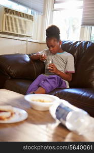 Girl With Poor Diet Eating Meal On Sofa At Home