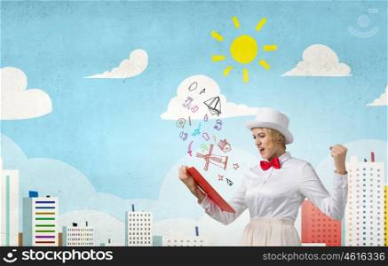 Girl with red book. Young emotional woman in white cylinder with book in hand