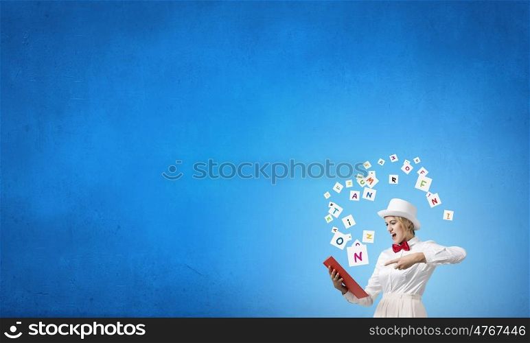 Girl with red book. Young emotional woman in white cylinder with book in hand