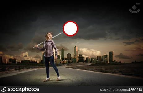 Girl with roadsign. Young woman in casual holding road sign