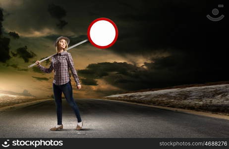 Girl with roadsign. Young woman in casual holding road sign