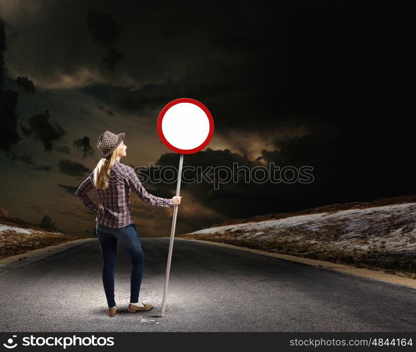 Girl with roadsign. Young woman in casual holding road sign