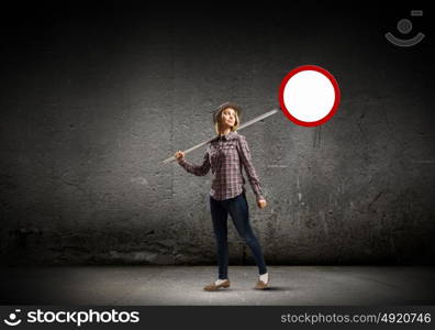 Girl with roadsign. Young woman in casual holding road sign