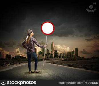 Girl with roadsign. Young woman in casual holding road sign