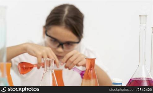 girl with safety glasses doing chemistry experiments