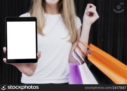 girl with shopping bags holding tablet mock up