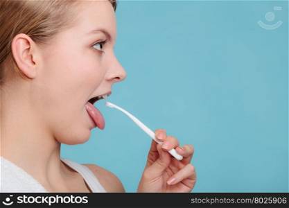 Girl with tongue cleaner.. Pretty young girl with cleaner. Happy woman cleaning her oral cavity caring about dental health display tongue.