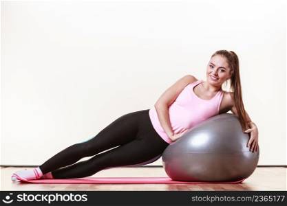 Girl with training equipment. Young female in gym with fit ball. Activity fitness health workout concept.. Girl exercising with fit ball