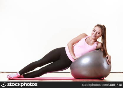 Girl with training equipment. Young female in gym with fit ball. Activity fitness health workout concept.. Girl exercising with fit ball