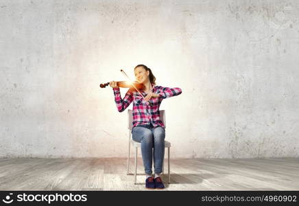 Girl with violin. Young pretty girl in casual playing violin