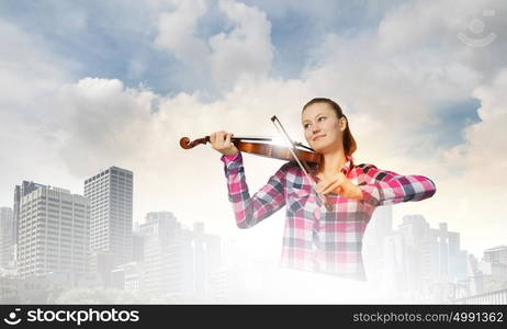 Girl with violin. Young pretty girl in casual playing violin