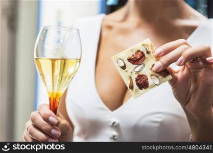 Girl with wine and chocolate, closeup photo