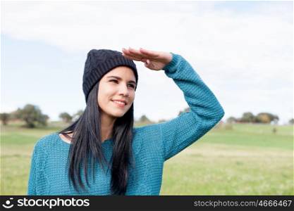 Girl with wool cap in the field looking away